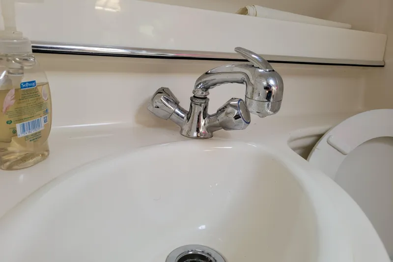 Slide: The Image of Chrome faucet and sink in a 2007 Stingray 250 CS boat bathroom. - 32
