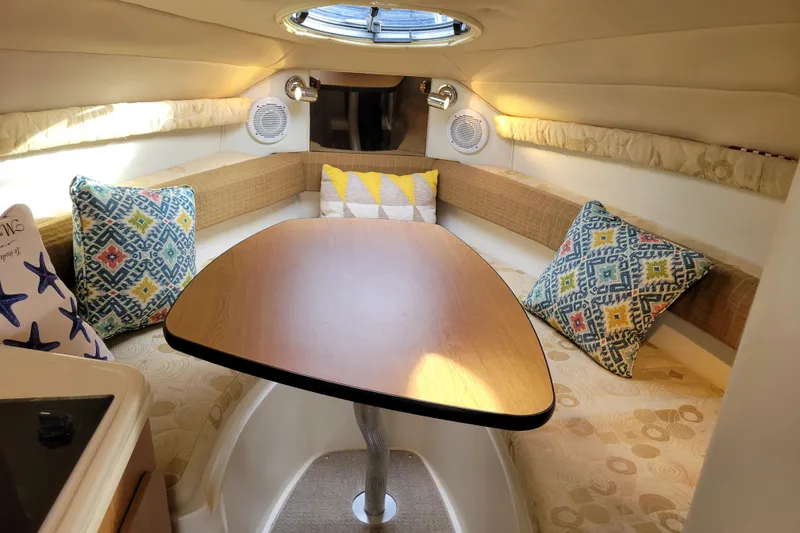 Slide: The Image of Cozy interior of 2007 Stingray 250 CS boat with colorful cushions and wooden table. - 34