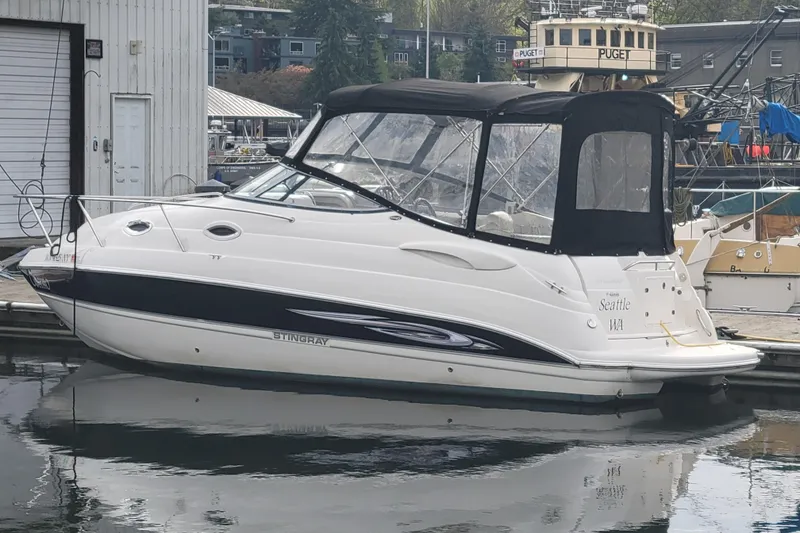 Slide: The Image of 2007 Stingray 250 CS boat docked in marina, featuring sleek design and black canopy. - 6