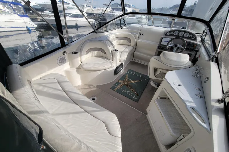 Slide: The Image of Interior of a 2007 Stingray 250 CS boat with white seating and dashboard. - 8