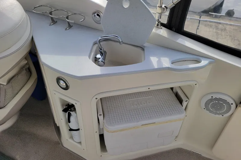 Slide: The Image of 2007 Stingray 250 CS boat interior with sink, cup holders, and Igloo cooler storage. - 9