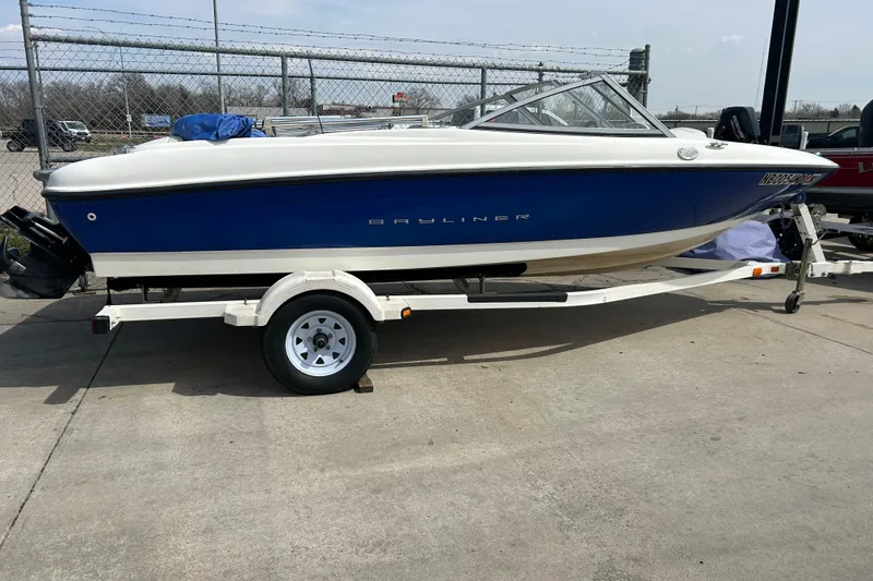The Image of 2007 Bayliner 175 boat on trailer, blue and white exterior, parked outdoors. - 0