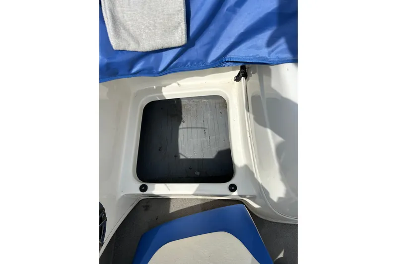 Slide: The Image of Open storage compartment on a 2007 Bayliner 175 boat with blue cover. - 11
