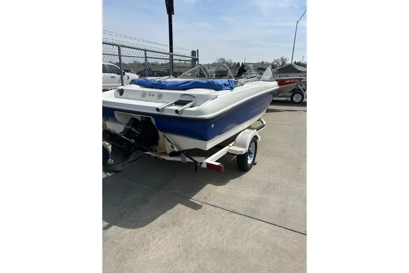 Slide: The Image of 2007 Bayliner 175 boat on trailer, parked outdoors, blue and white color scheme. - 3