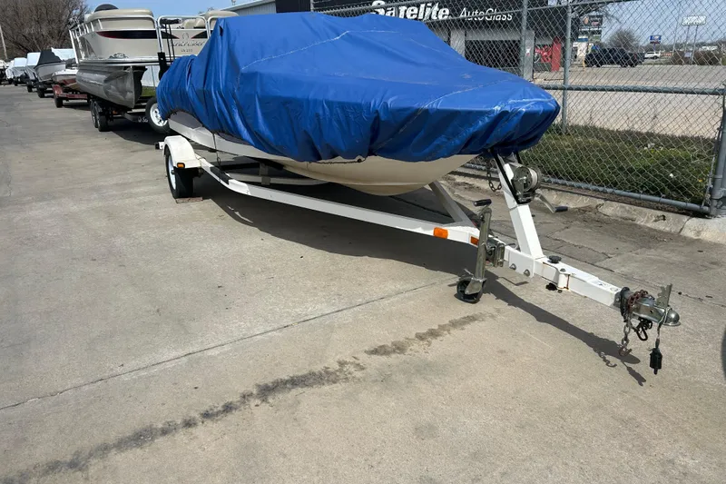Slide: The Image of 2007 Bayliner 175 boat on trailer, covered with blue tarp, parked outdoors. - 4