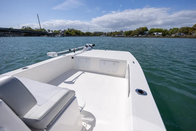Slide: The Image of 2022 Bay Rider 2260 Skiff on calm water, showcasing spacious deck and seating. - 14