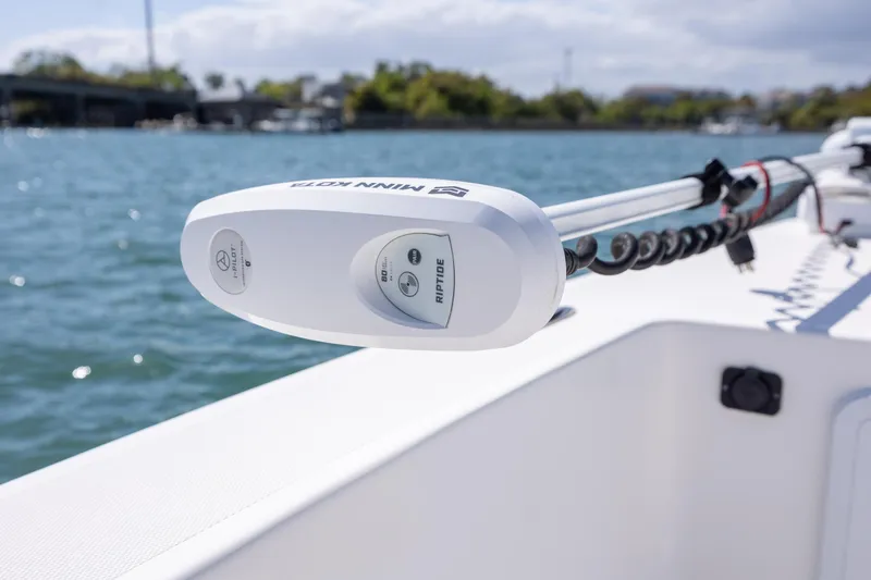 Slide: The Image of Minn Kota Riptide motor on 2022 Bay Rider 2260 Skiff, docked by the water. - 15