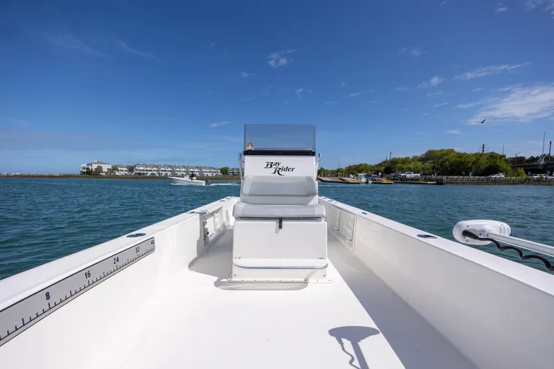 Slide: The Image of 2022 Bay Rider 2260 Skiff on water, clear sky, coastal background. - 17