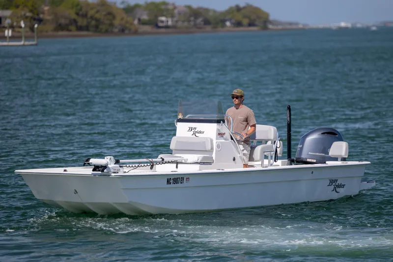 Slide: The Image of 2022 Bay Rider 2260 Skiff cruising on a calm lake with a person steering. - 3