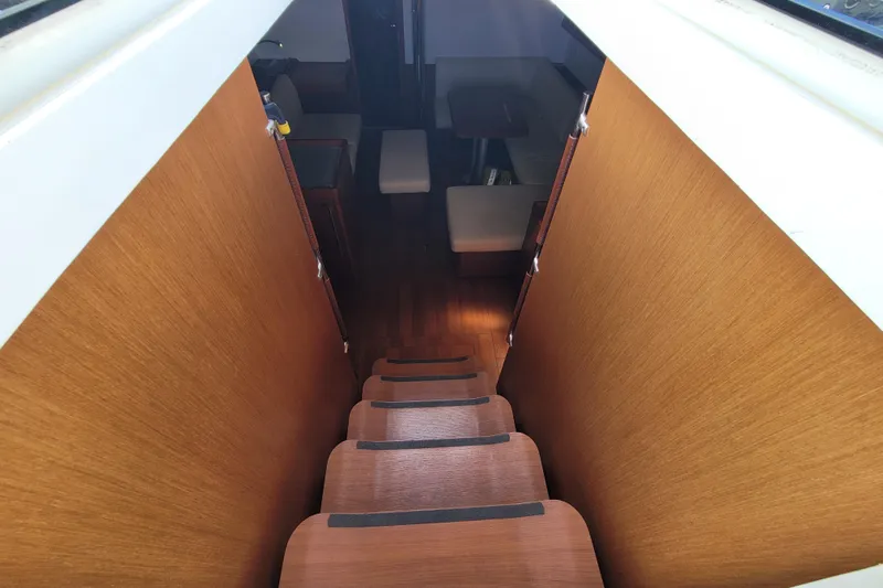 Slide: The Image of Interior view of 2015 Beneteau Oceanis 45 yacht, featuring wooden stairs leading to cabin. - 14