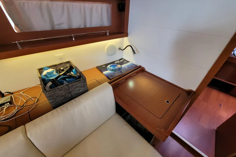 Slide: The Image of Interior of 2015 Beneteau Oceanis 45 yacht with wooden desk and cozy seating area. - 18