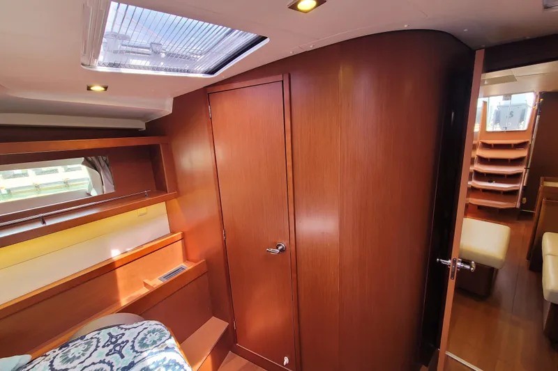 Slide: The Image of Interior of 2015 Beneteau Oceanis 45 yacht, featuring wood paneling and cozy cabin space. - 20