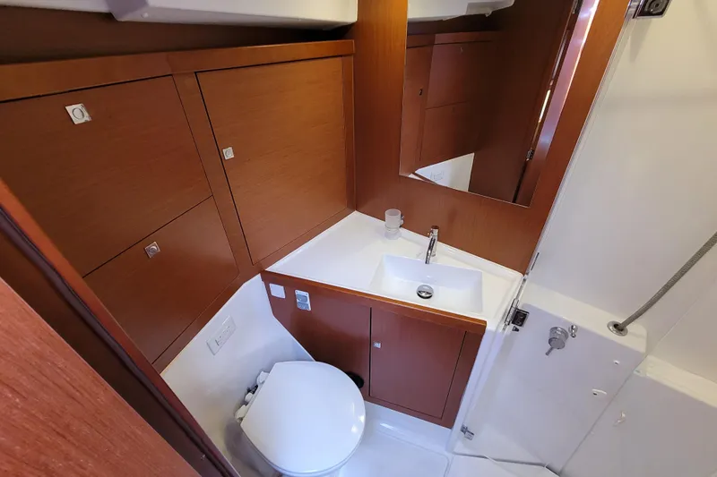 Slide: The Image of Beneteau Oceanis 45 (2015) yacht bathroom with wooden cabinets and modern fixtures. - 21