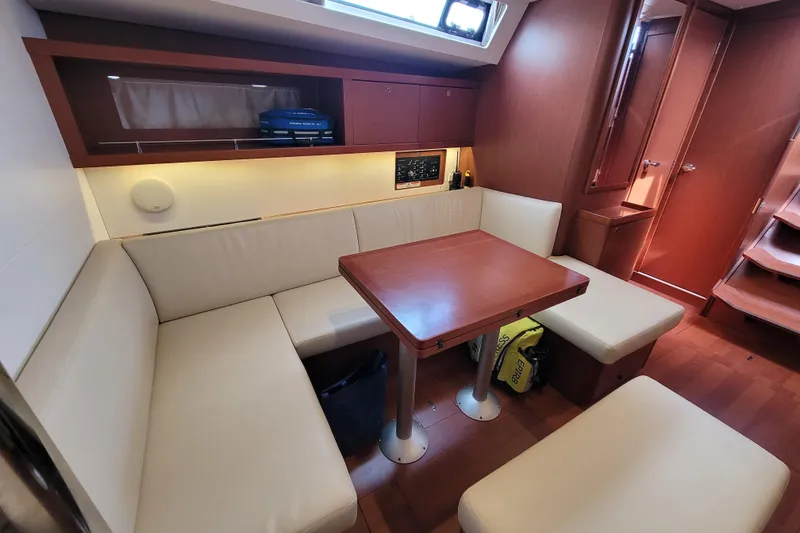 Slide: The Image of Interior of 2015 Beneteau Oceanis 45 yacht with cozy seating and wooden table. - 23