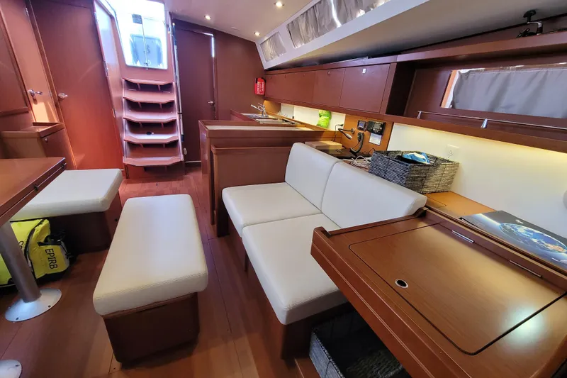 Slide: The Image of Interior of 2015 Beneteau Oceanis 45 yacht, featuring modern seating and wooden cabinetry. - 24