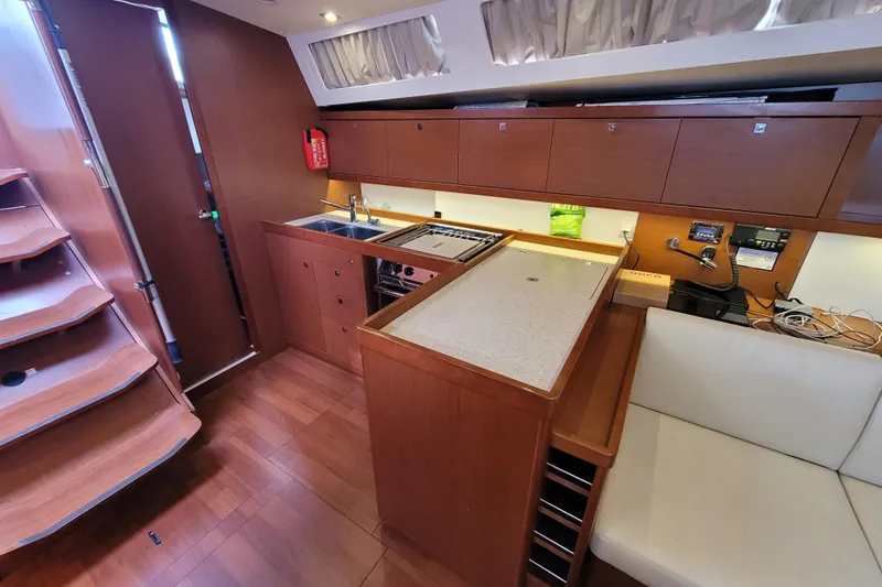Slide: The Image of Interior of 2015 Beneteau Oceanis 45 yacht, featuring a modern kitchen and seating area. - 25