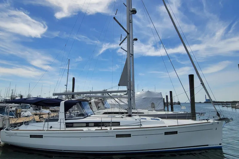 Slide: The Image of 2015 Beneteau Oceanis 45 sailboat docked under a clear blue sky. - 3