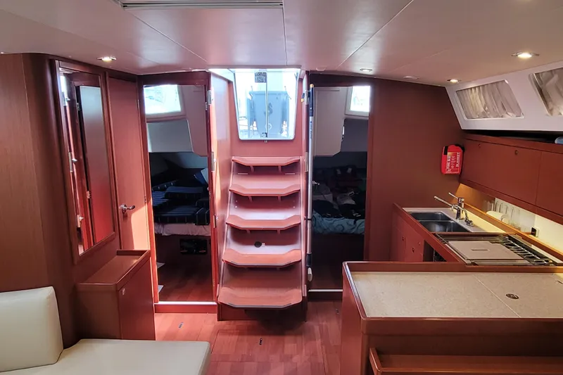 Slide: The Image of Interior of 2015 Beneteau Oceanis 45 yacht, featuring wood finishes and modern kitchen amenities. - 30