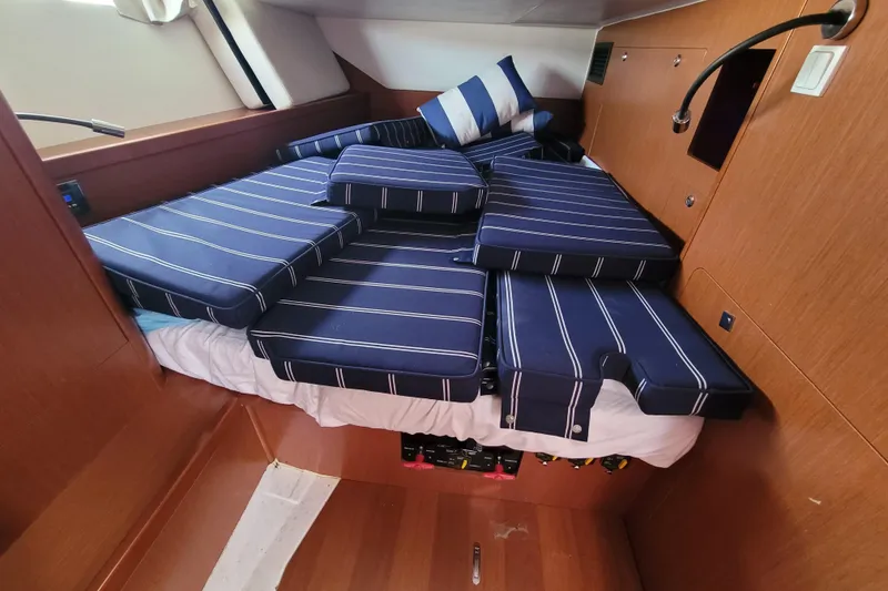 Slide: The Image of Interior of a 2015 Beneteau Oceanis 45 yacht with striped cushions on a bed. - 31