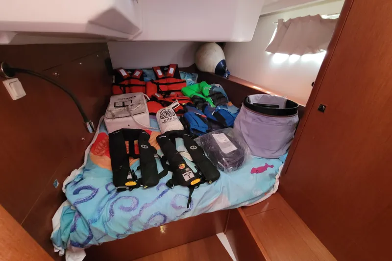 Slide: The Image of Safety gear and equipment on a 2015 Beneteau Oceanis 45 yacht cabin bed. - 32