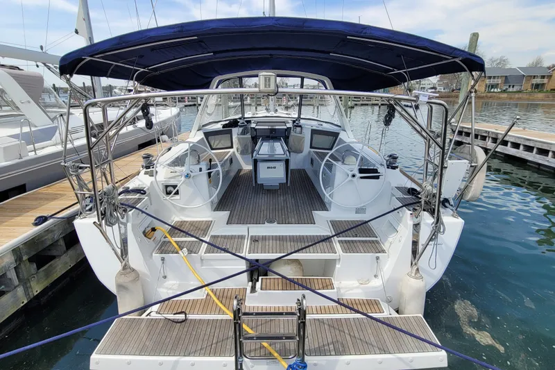 Slide: The Image of 2015 Beneteau Oceanis 45 sailboat docked, featuring dual steering wheels and spacious cockpit. - 4