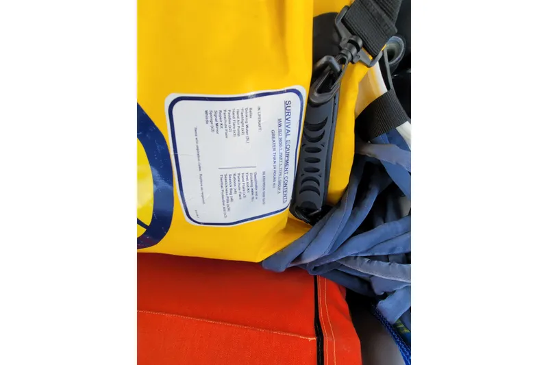 Slide: The Image of Yellow survival equipment bag with label, straps, and blue fabric on a Beneteau Oceanis 45. - 48