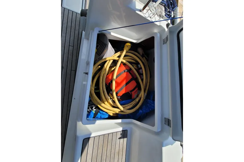 Slide: The Image of Storage compartment on a 2015 Beneteau Oceanis 45 yacht with coiled yellow hose. - 52