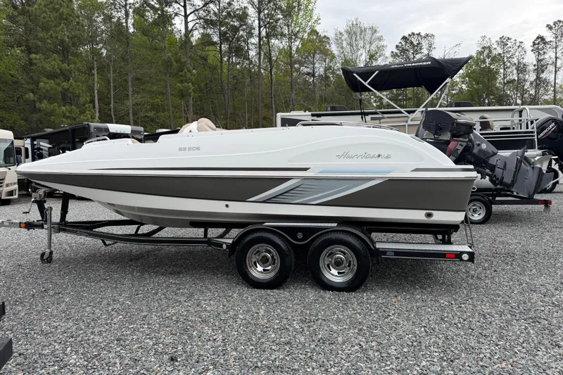 Slide: The Image of 2016 Hurricane SunDeck Sport 202 OB boat on trailer, parked outdoors. - 21