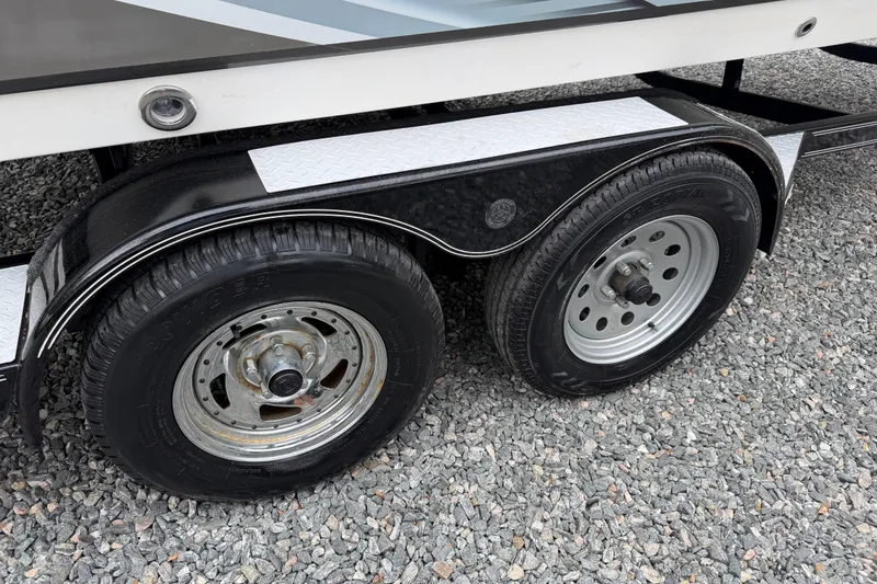 Slide: The Image of Trailer wheels of a 2016 Hurricane SunDeck Sport 202 OB on gravel surface. - 5
