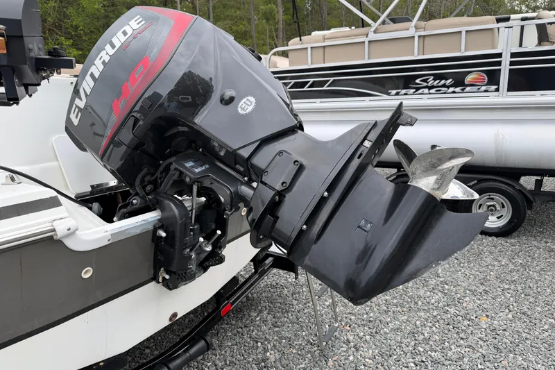 Slide: The Image of 2016 Hurricane SunDeck Sport 202 OB with Evinrude outboard motor, parked on gravel. - 7