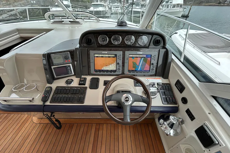 Slide: The Image of 2009 Sea Ray 480 Sundancer helm with navigation screens and controls on teak deck. - 9