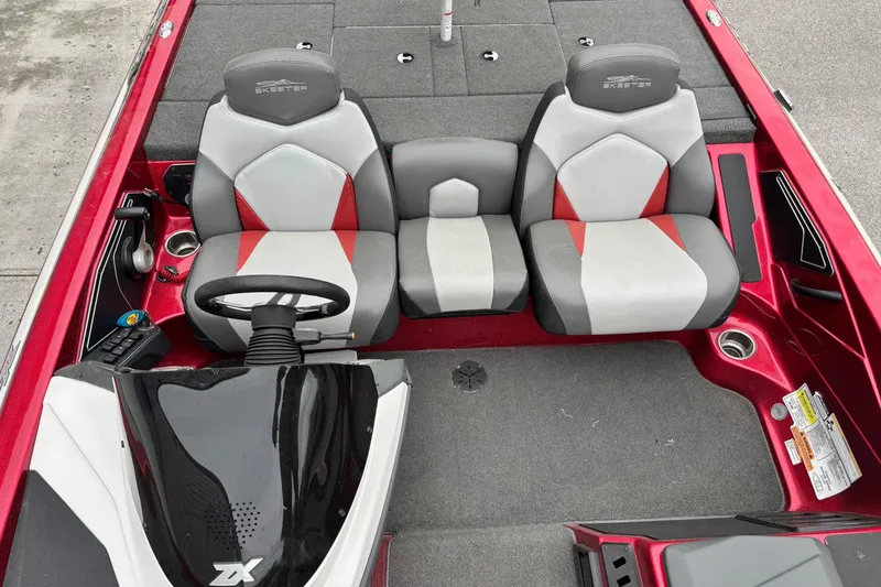 Slide: The Image of 2016 Skeeter ZX200 boat interior with red and gray seating and steering console. - 7