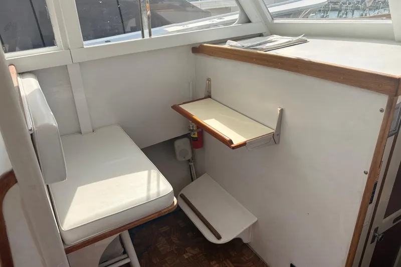 Slide: The Image of 1980 Custom Chesapeake boat interior with white seating and foldable table. - 12