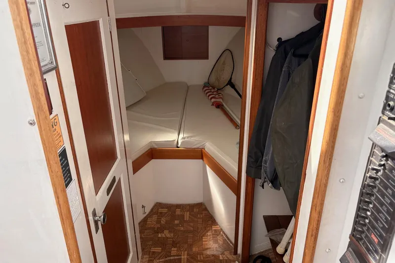 Slide: The Image of Cozy cabin interior of a 1980 Custom Chesapeake boat with wooden accents and storage space. - 14