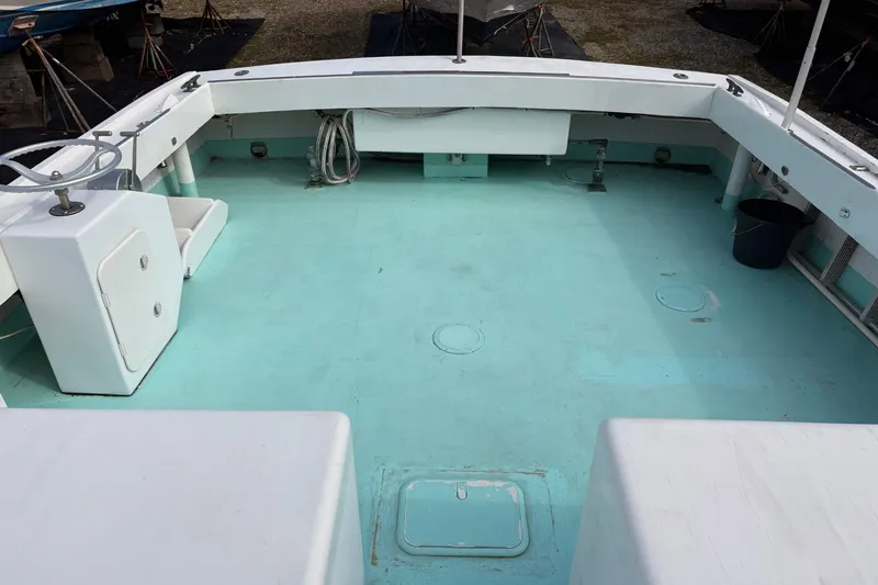 Slide: The Image of 1980 Custom Chesapeake boat deck with light blue flooring and white seating. - 4