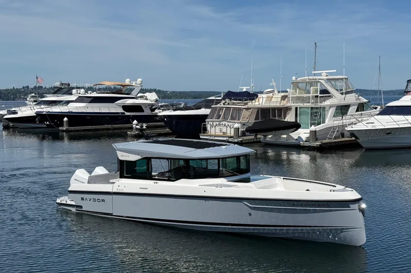 The Image of 2026 Saxdor 320 GTC boat docked in a marina, surrounded by other yachts. - 0