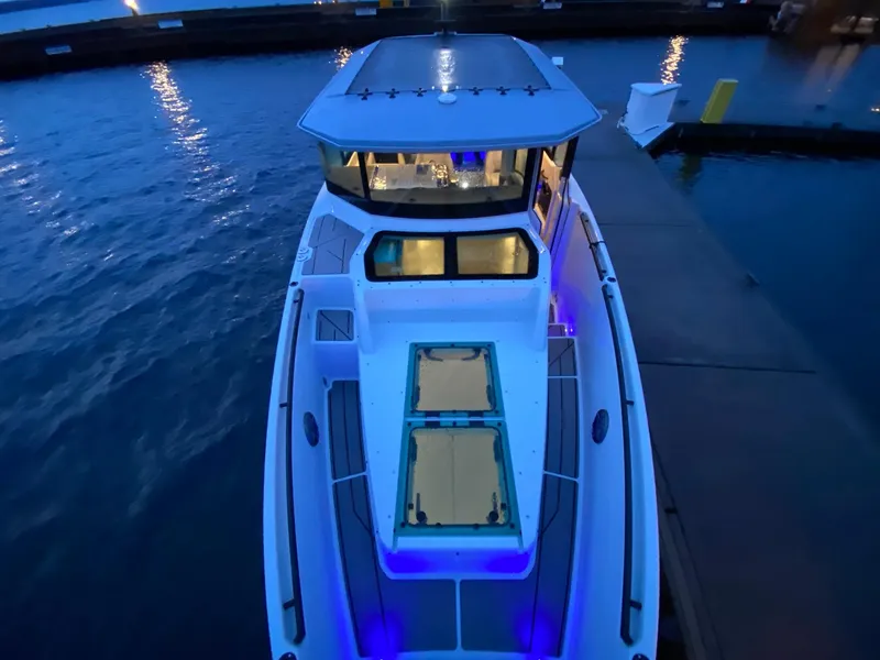 Slide: The Image of 2025 Saxdor 320 GTC boat docked at night with blue LED lights. - 11