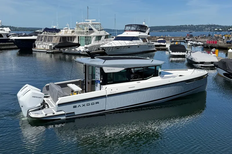 Slide: The Image of 2026 Saxdor 320 GTC boat docked in a marina, featuring sleek design and Mercury engines. - 3
