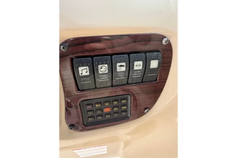 Slide: The Image of Control panel of a 2003 Chaparral 230 SSi boat with various switches. - 17