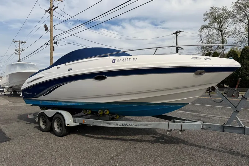 Slide: The Image of 2003 Chaparral 230 SSi boat on trailer, parked outdoors under cloudy sky. - 2