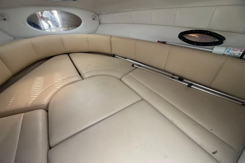 Slide: The Image of 2003 Chaparral 230 SSi boat interior with beige seating and oval window. - 20