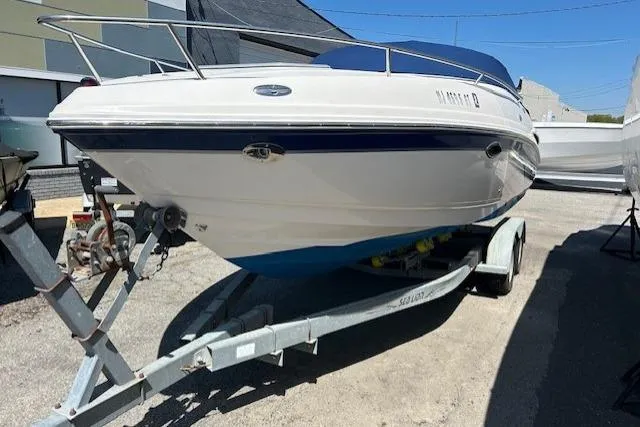 Slide: The Image of 2003 Chaparral 230 SSi boat on trailer, white and blue, parked outdoors. - 3