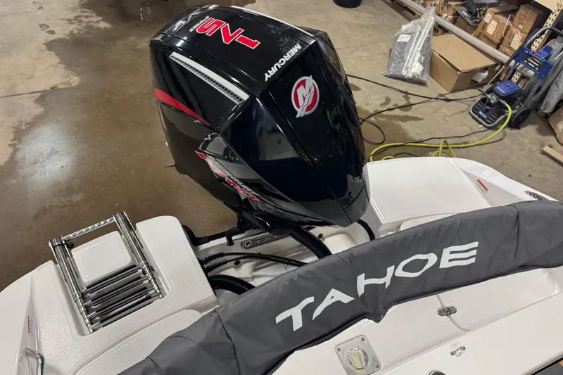 Slide: The Image of 2025 Tahoe 1950 boat with Mercury outboard motor in a workshop setting. - 13