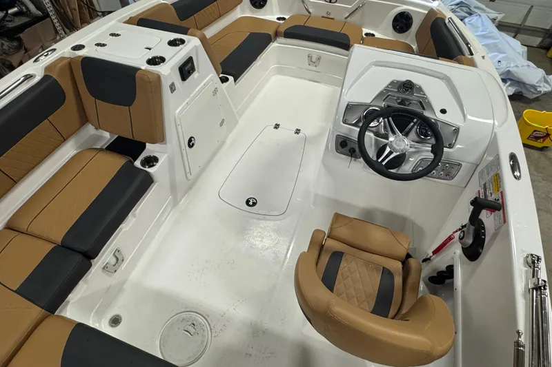 Slide: The Image of Interior of a 2025 Tahoe 1950 boat with tan and black seating, steering wheel, and controls. - 14