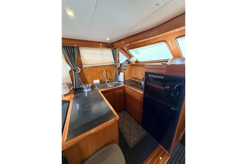 Slide: The Image of Luxurious 2003 Mikelson Sportfisher yacht kitchen with wood cabinetry and modern appliances. - 11