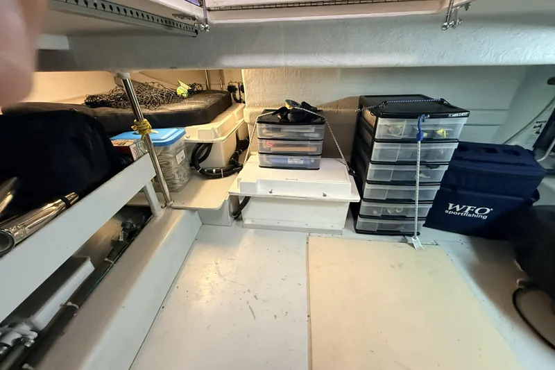 Slide: The Image of Storage area on a 2003 Mikelson Sportfisher boat with organized fishing gear and equipment. - 13