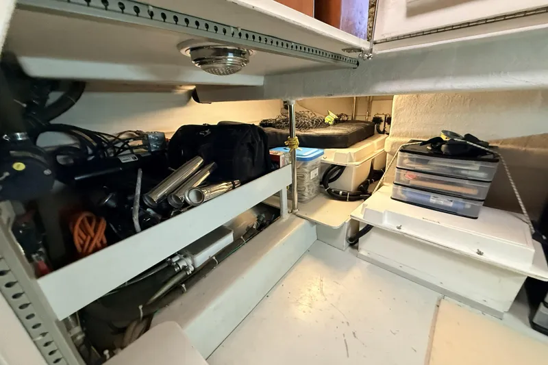 Slide: The Image of Storage area inside a 2003 Mikelson Sportfisher boat, featuring organized shelves and equipment. - 14
