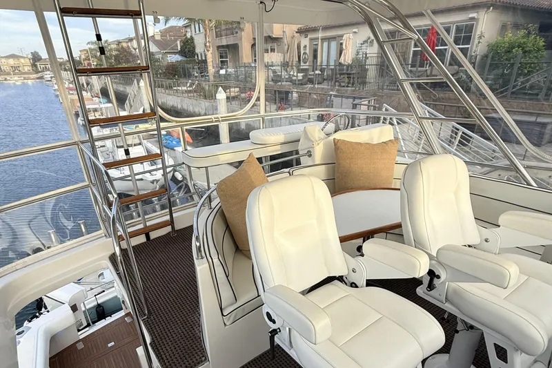 Slide: The Image of Interior of a 2003 Mikelson Sportfisher yacht with white seating and marina view. - 21