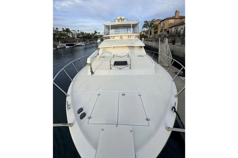 Slide: The Image of 2003 Mikelson Sportfisher yacht docked in a marina, showcasing spacious deck and sleek design. - 26