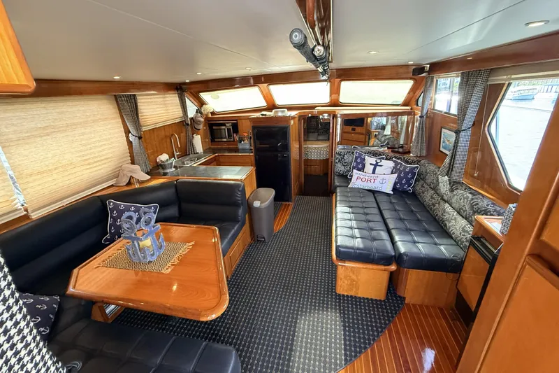 Slide: The Image of Luxurious interior of a 2003 Mikelson Sportfisher yacht with elegant wood finishes and plush seating. - 8